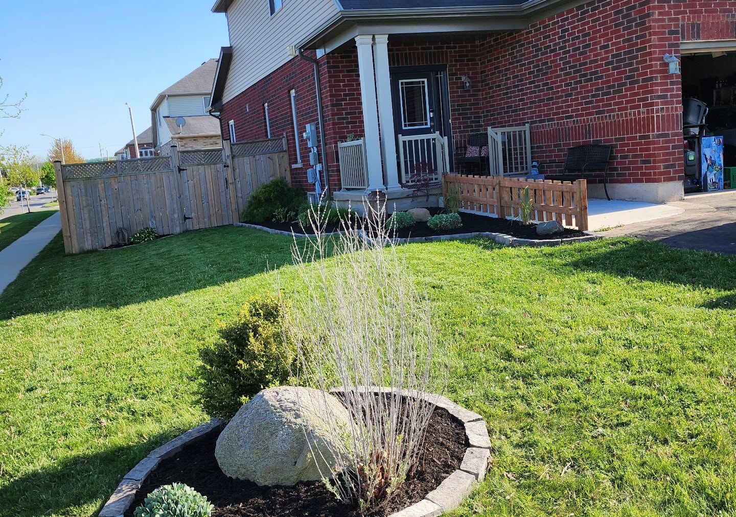 Front garden bed with armour stone, new mulch and stone edging